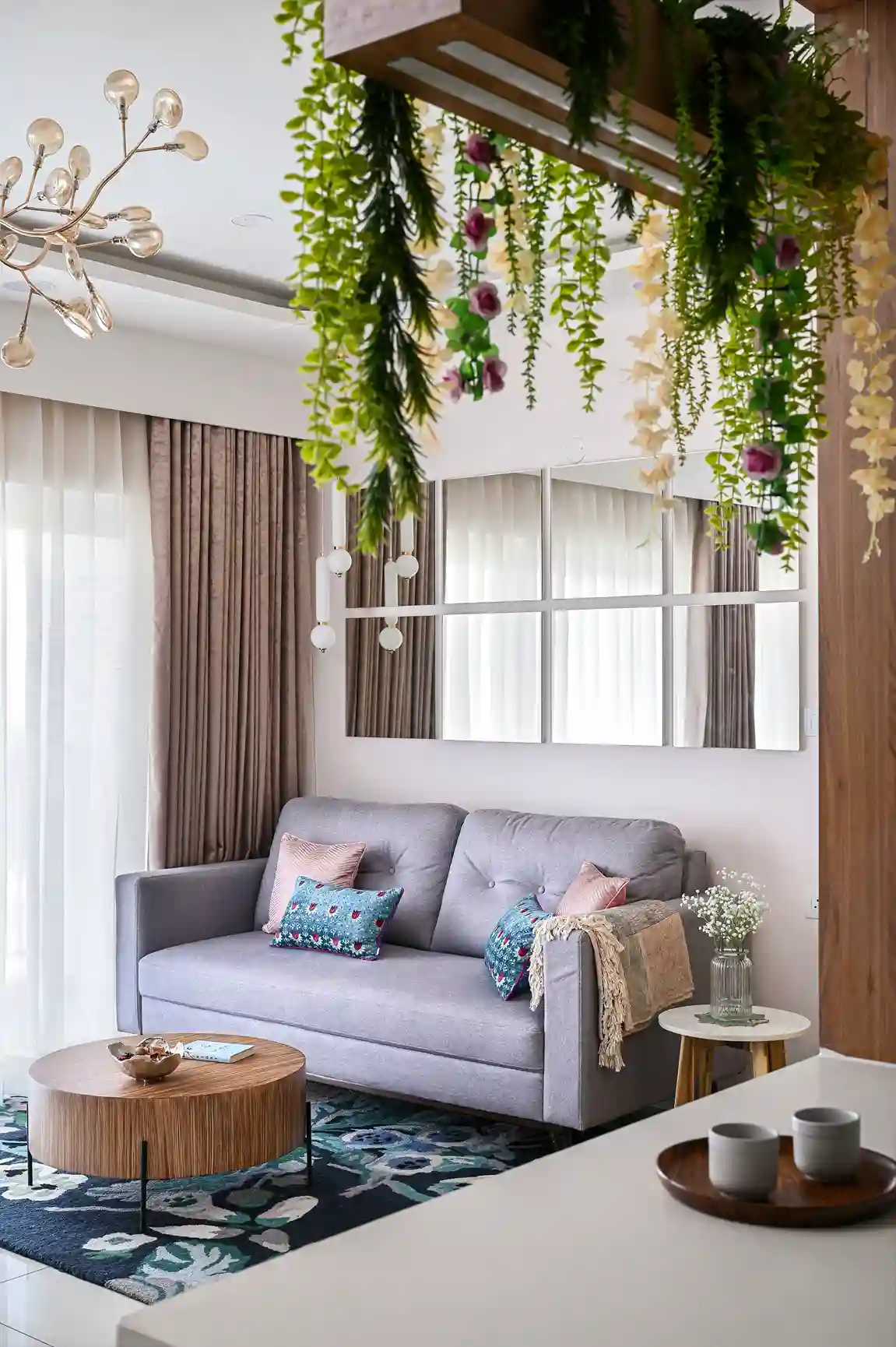 A luxury living room interior with a premium couch and decorative pillows complemented with greenery and wall mirrors